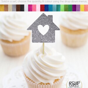 May include: Silver glitter cupcake topper shaped like a house with a heart cut out. The topper is on a cupcake with white frosting. The text "RSVP Party Decor" is visible in the bottom right corner of the image.