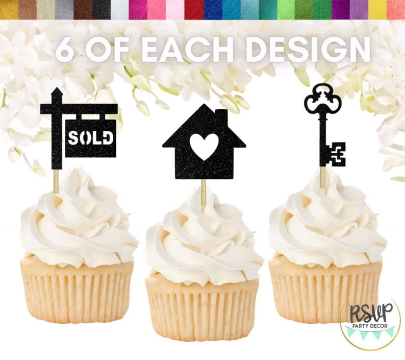 Peut inclure: Six d&eacute;corations de cupcakes avec une finition en paillettes noires. Les d&eacute;corations repr&eacute;sentent une maison avec un c&oelig;ur, une cl&eacute; et un panneau "vendu". Les d&eacute;corations sont plac&eacute;es sur des cupcakes avec un gla&ccedil;age blanc.