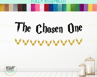 May include: A black and gold glitter banner with the text "The Chosen One" and a string of gold glitter Harry Potter Golden Snitch charms.
