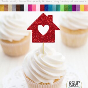 May include: Red glitter cupcake topper shaped like a house with a heart cut out. The topper is on a cupcake with white frosting. The text "RSVP Party Decor" is visible in the image.