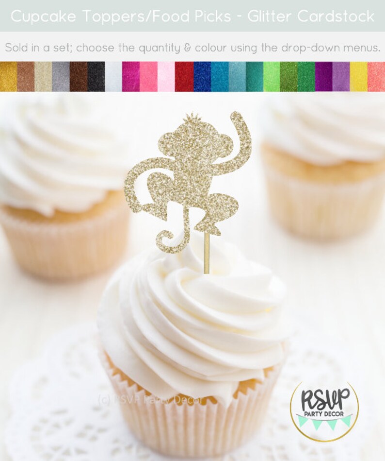 K&ouml;nnte beinhalten: Goldener Glitzer-Affen-Cupcake-Topper. Der Affe sitzt mit einem erhobenen Arm. Der Topper befindet sich auf einem wei&szlig;en Cupcake mit wei&szlig;em Frosting.