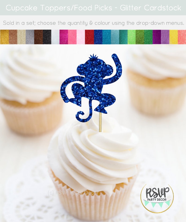 K&ouml;nnte beinhalten: Blauer Glitzer-Affen-Cupcake-Topper. Der Affe sitzt mit einem erhobenen Arm. Der Topper befindet sich auf einem wei&szlig;en Cupcake mit wei&szlig;em Frosting.