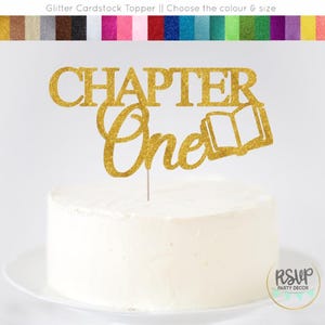 May include: A gold glitter cardstock cake topper that reads "CHAPTER One" with an open book icon. The topper is on a white frosted cake. The top of the image shows a color chart.