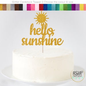May include: Gold glitter cardstock cake topper with a sun and the words "hello sunshine".