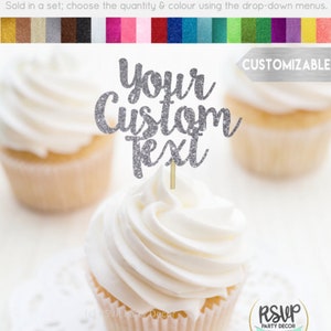 May include: Silver glitter cupcake topper with the text "Your Custom Text". The topper is on a white cupcake with white frosting. The cupcake is on a white doily.