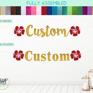 May include: Gold glitter "Custom" banner with red glitter hibiscus flowers. The banner is strung on a white string. The banner is fully assembled and ready to hang.