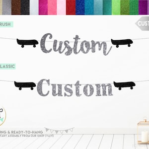 K&ouml;nnte beinhalten: Ein silberner Glitzerbanner mit dem Wort "Custom" in zwei verschiedenen Schriftarten. Der Banner ist mit schwarzen Papierschnitten von Skateboards bespannt. Der Banner ist vorgespannt und bereit zum Aufh&auml;ngen. Der Text "FONT #5: BRUSH" und "FONT #6: CLASSIC" ist oben im Bild sichtbar. Der Text "CUSTOMIZABLE" ist oben rechts im Bild sichtbar.
