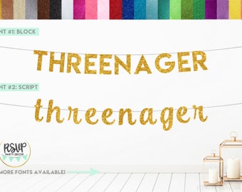 May include: Gold glitter banner with the words "THREENAGER" in block letters and "threenager" in script letters. The banner is hanging on a white wall with a wooden floor.