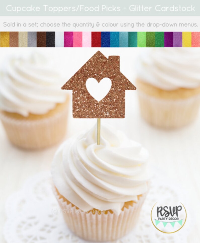 May include: A cupcake topper featuring a glitter-covered house with a heart cut-out. The topper is made of cardstock and is perfect for adding a touch of whimsy to cupcakes.