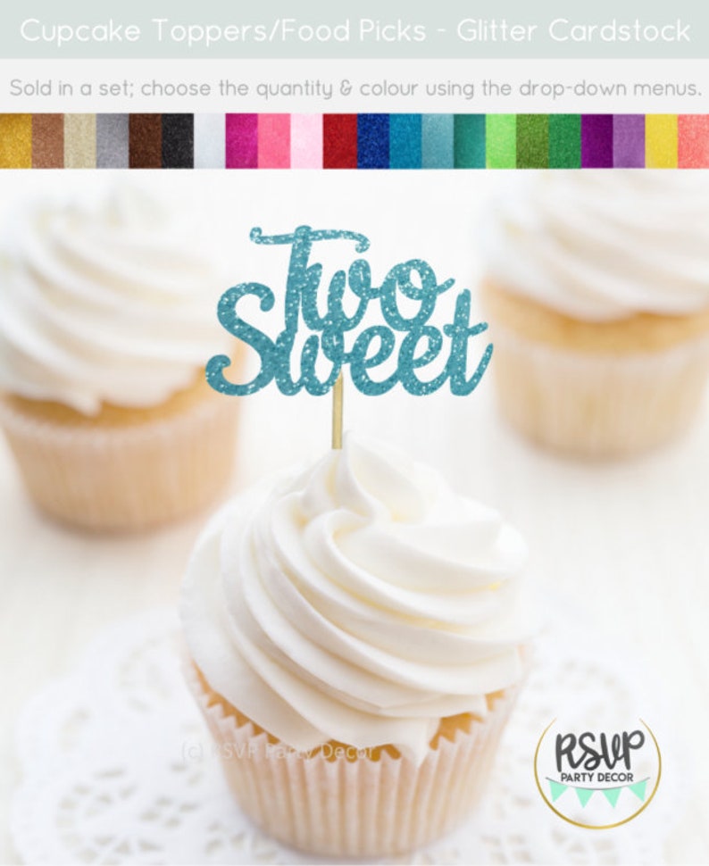 May include: Two blue glitter cupcake toppers with the text "Two Sweet" on a white cupcake with white frosting.