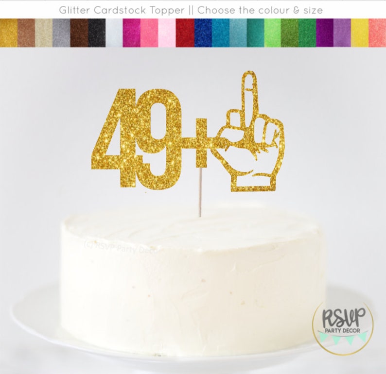 May include: Gold glitter cardstock cake topper with the number 49 and a hand with the middle finger raised. The text "49+" is on the topper.