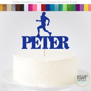 以下が含まれることがあります： 青いグリッターの厚紙製のケーキトッパー。走っている人物と「PETER」という名前が大きな文字で書かれています。