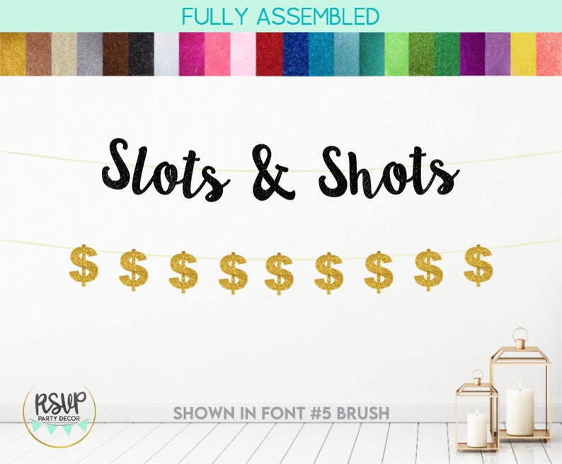 May include: A black glitter banner with the text "Slots & Shots" and gold glitter dollar signs hanging from a string. The banner is fully assembled and shown in font #5 brush.
