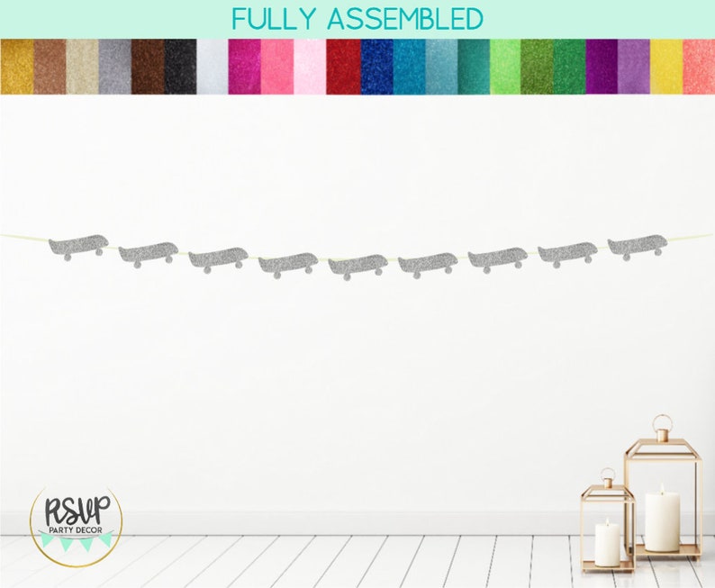 Op de afbeelding: Een zilveren glitter skateboard banner met de tekst "RSVP Party Decor" op een witte achtergrond.