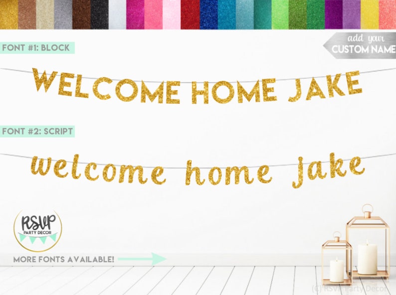 Pode incluir: Faixa de boas-vindas para casa em glitter dourado com o nome Jake em letras de bloco e cursivas. A faixa est&aacute; pendurada em uma parede branca com duas lanternas douradas em um piso de madeira.