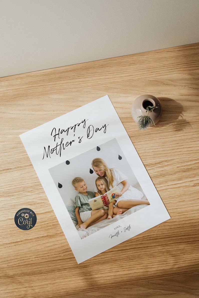 May include: A white card with the text "Happy Mother's Day" in black script. A photo of a mother reading a book to her two children is below the text. The photo is surrounded by black raindrops. The text "LOVE, Faith & Seth" is at the bottom of the card.