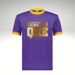 May include: Purple t-shirt with gold text that reads "THE FUTURE ONE". The shirt has a yellow collar and sleeve trim. The text is in a gold, blocky font. The shirt is a crew neck style.