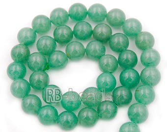 Op de afbeelding: Een streng ronde, groene jade kralen. De kralen zijn glad en gepolijst en geregen aan een doorzichtig draad.