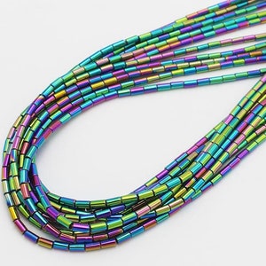 May include: A strand of iridescent rainbow colored metal beads. The beads are small and cylindrical in shape.