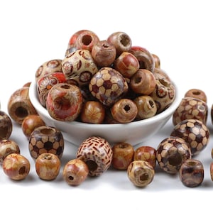 May include: A bowl filled with wooden beads in various patterns, including football designs, floral patterns, and geometric designs. The beads are brown, red, and white.