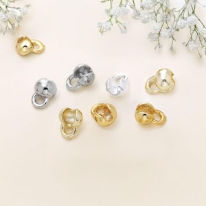 Puede incluir: Surtido de pequeñas tapas de cuentas redondas de metal en acabados plateado, dorado y latón. Las tapas tienen un bucle en un lado y un pequeño agujero en el otro.