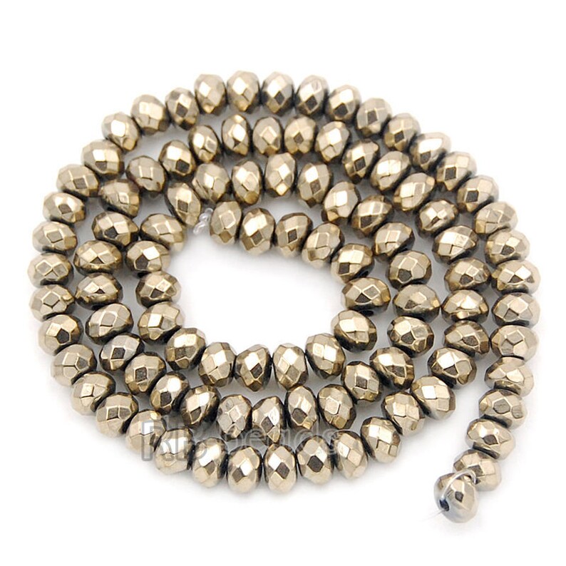 May include: A strand of gold-toned faceted beads. The beads are round and have a metallic finish.