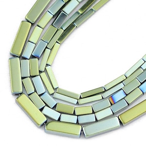 Peut inclure: Un brin de perles rectangulaires en pierre précieuse irisées vertes et bleues. Les perles sont facettées et ont un éclat métallique.