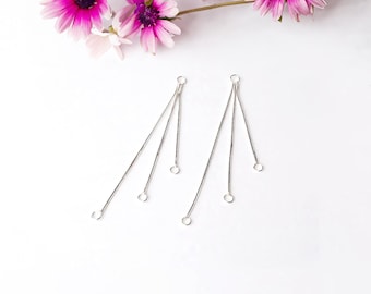 May include: A pair of silver earring findings with three dangling loops at the bottom.