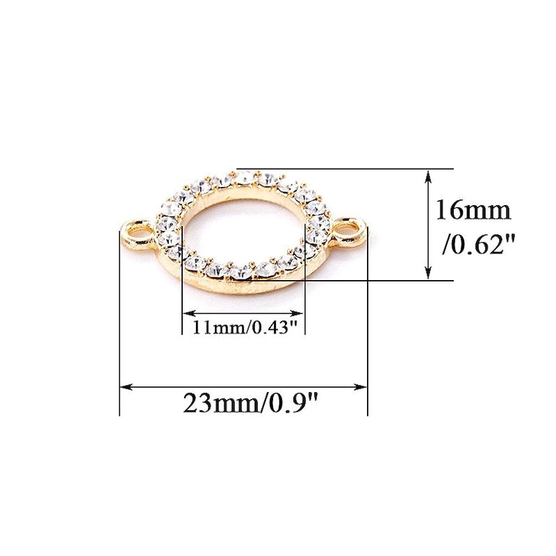 Op de afbeelding: Gouden metalen connector met een cirkel van heldere strass steentjes. De connector meet 16 mm in diameter en 23 mm in lengte.