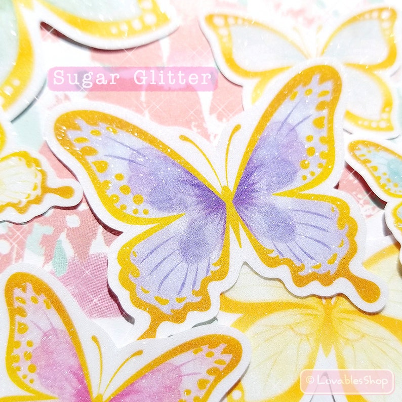 May include: A set of colorful butterfly stickers with a glittery finish. The butterflies are in shades of purple, pink, yellow, and blue. The text "Sugar Glitter" is printed on the sticker sheet.