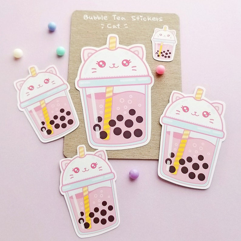 Puede incluir: Cuatro pegatinas de t&eacute; de burbujas rosas y blancas con una cara de gato en la tapa. El texto "Bubble Tea Stickers >Cat<" est&aacute; sobre un fondo marr&oacute;n.