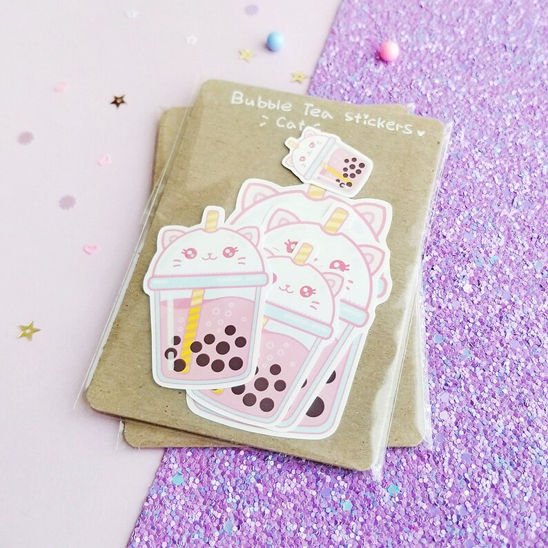 Puede incluir: Un conjunto de cuatro pegatinas de t&eacute; de burbujas rosa y blanco con lindas caras de gato. Las pegatinas dicen "Bubble Tea Stickers" y "Cat" en el empaque.