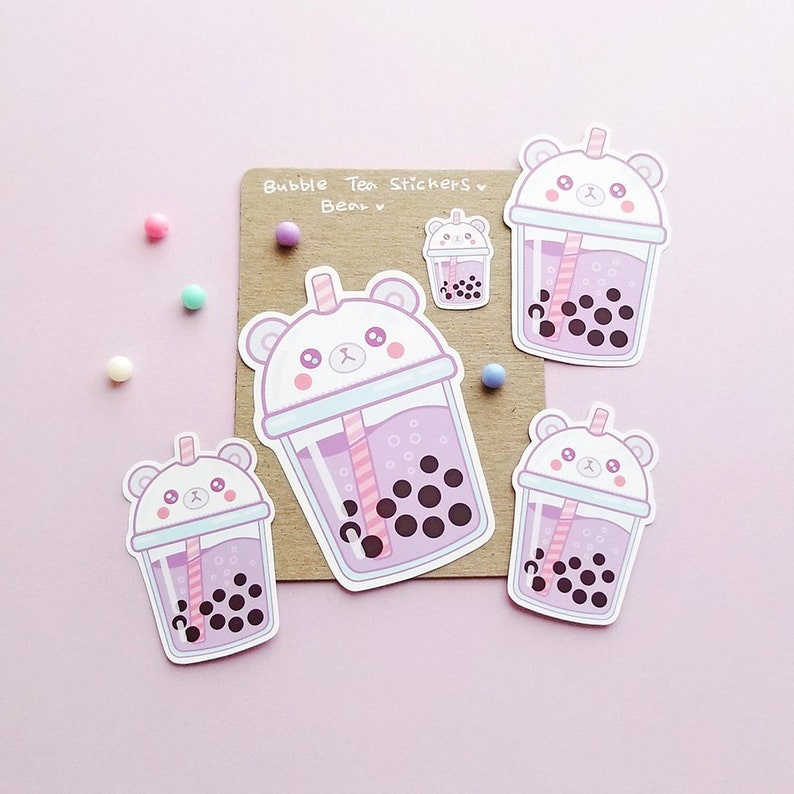 Puede incluir: Cuatro pegatinas con un oso de dibujos animados que lleva una taza de t&eacute; de burbujas rosa y blanca. Las pegatinas est&aacute;n sobre un fondo marr&oacute;n con el texto "Bubble Tea Stickers" y "Bear" escrito en negro.