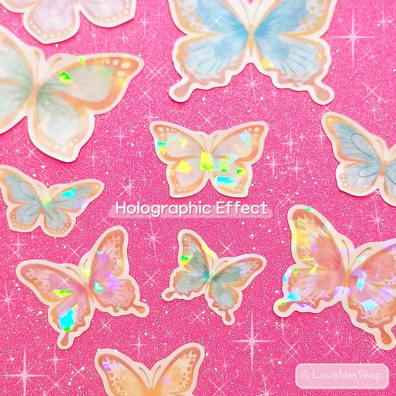 May include: A sheet of holographic butterfly stickers with a pink glitter background. The butterflies are in various shades of blue, pink, and orange.
