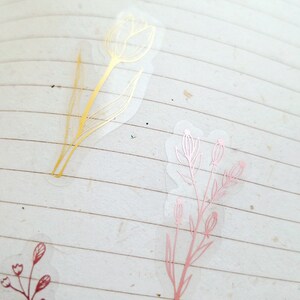 May include: Three clear stickers with gold and rose gold floral designs. The stickers feature a tulip and two sprigs of flowers.