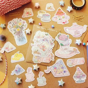 May include: A sheet of stickers featuring a tea party theme. The stickers are colorful and feature images of teacups, teapots, flowers, and pastries. The text "Tea Party Stickers" is printed on the sheet.