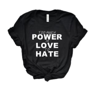 May include: Black t-shirt with white text that reads "Too much power in love to hate."