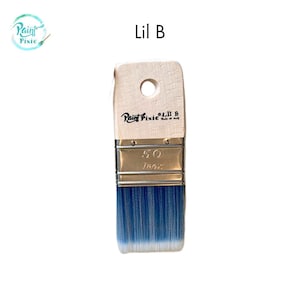 May include: A paint brush with a wooden handle and blue bristles. The handle has a hole for hanging and the text "Paint Pixie" and "Lil B" are printed on the handle. The metal ferrule is stamped with "50 1802".