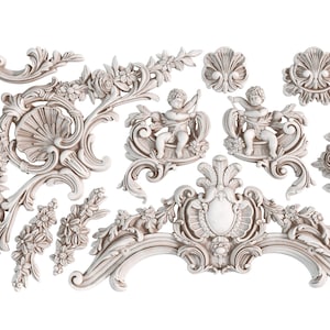 May include: A collection of ornate, off-white decorative elements. The assortment includes floral garlands, cherub figures, shell-shaped designs, and various scrollwork pieces. These elements are likely for interior design or craft projects.
