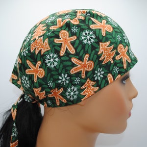 May include: Green scrub hat with a Christmas gingerbread man and tree pattern.