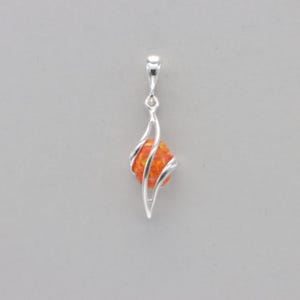 May include: A silver pendant with a swirling design that holds a round orange opal.