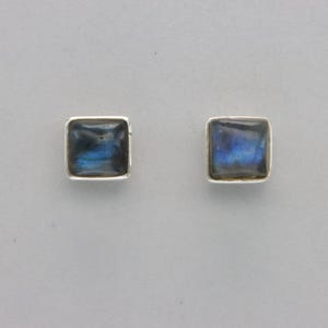 May include: A pair of silver stud earrings with square-shaped blue labradorite gemstones.