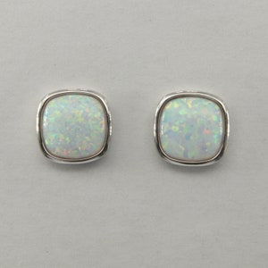 Puede incluir: Un par de pendientes de plata con piedras de ópalo blanco engastadas en forma cuadrada.