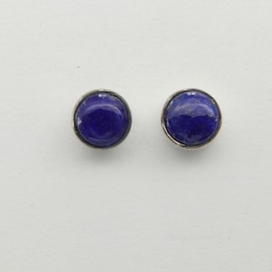 May include: A pair of silver stud earrings with round blue lapis lazuli stones.