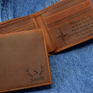 May include: A brown leather wallet with a compass and the text "Wherever your journey in life may take you, I pray you'll always be safe, enjoy the ride, and never forget your way back home. I'm always here for you... Love, Mom" engraved on the inside. The outside of the wallet has a personalized inscription with the letter "S" and the name "Smith" with antlers on either side.