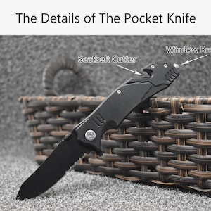 May include: A black pocket knife with a serrated blade, a seatbelt cutter, and a window breaker. The text "The Details of The Pocket Knife" is at the top of the image. The knife is resting on a woven basket.