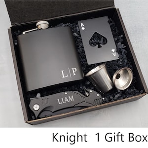 May include: Black gift box with a black flask, a black pocket knife, a shot glass, and a black card with a cut-out spade. The flask is engraved with the initials "L|P" and the pocket knife is engraved with the name "LIAM".