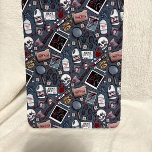 May include: A rectangular item with a dark teal background, patterned with crime scene elements. The design includes skulls, magnifying glasses, evidence markers, blood splatters, and the word "BLEACH".