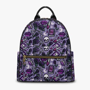 May include: A purple backpack with a black handle and zip. The backpack has a repeating pattern of skulls, roses, daggers, books, and lips. The design is in shades of purple, black, and white.
