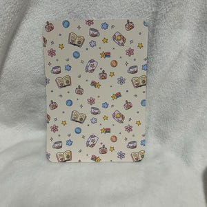 May include: A white background with a repeating pattern of colorful illustrations. The illustrations include a book, a cup of coffee, a candle, a rainbow, a star, and a flower.